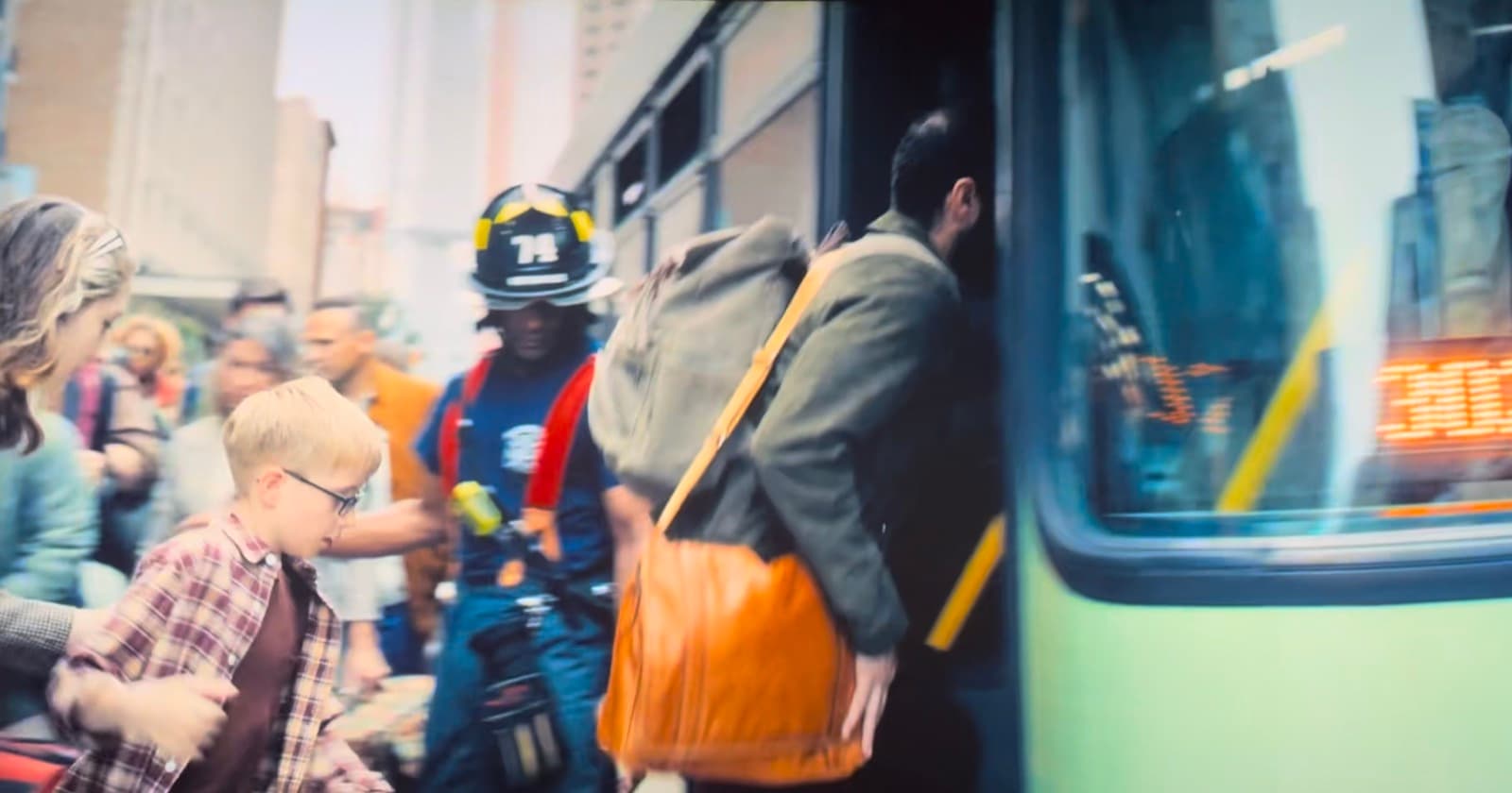 Owen visible among the extras boarding a bus in Superman (2025)